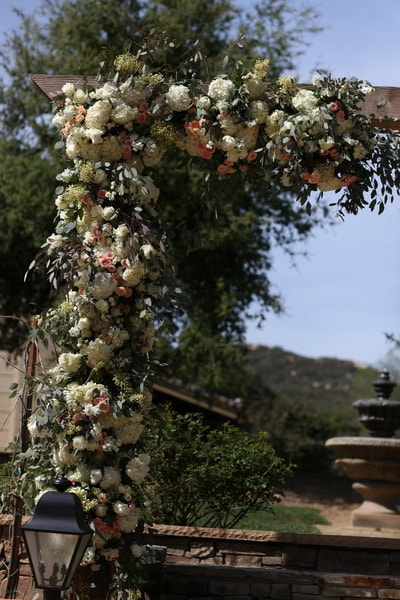 The perfect wedding spot under a floral arch at this private venue.