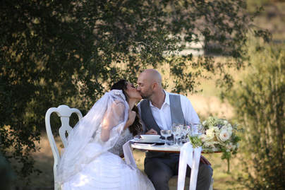 Bride and Groom kissing at sweetheart table at a private wedding.